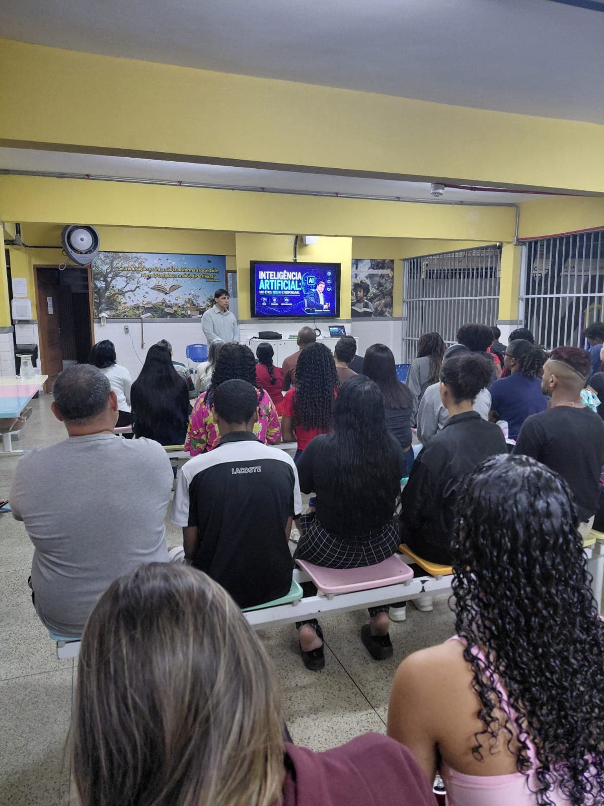 Palestra sobre segurança digital para uma turma de estudantes, com apresentação sobre inteligência artificial projetada na tela